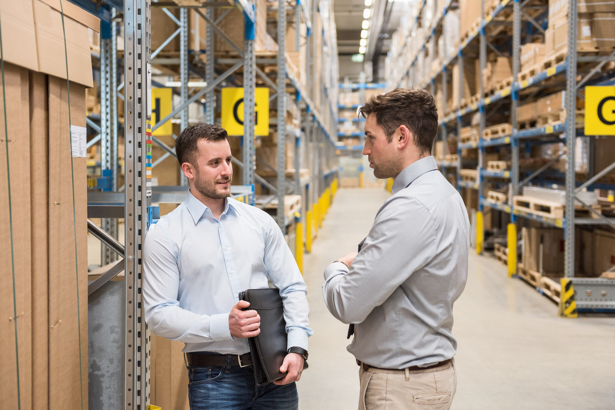 Two men talking in factory warehous
